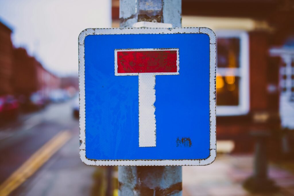 Dead End blue, rectangular sign with a T-shaped path