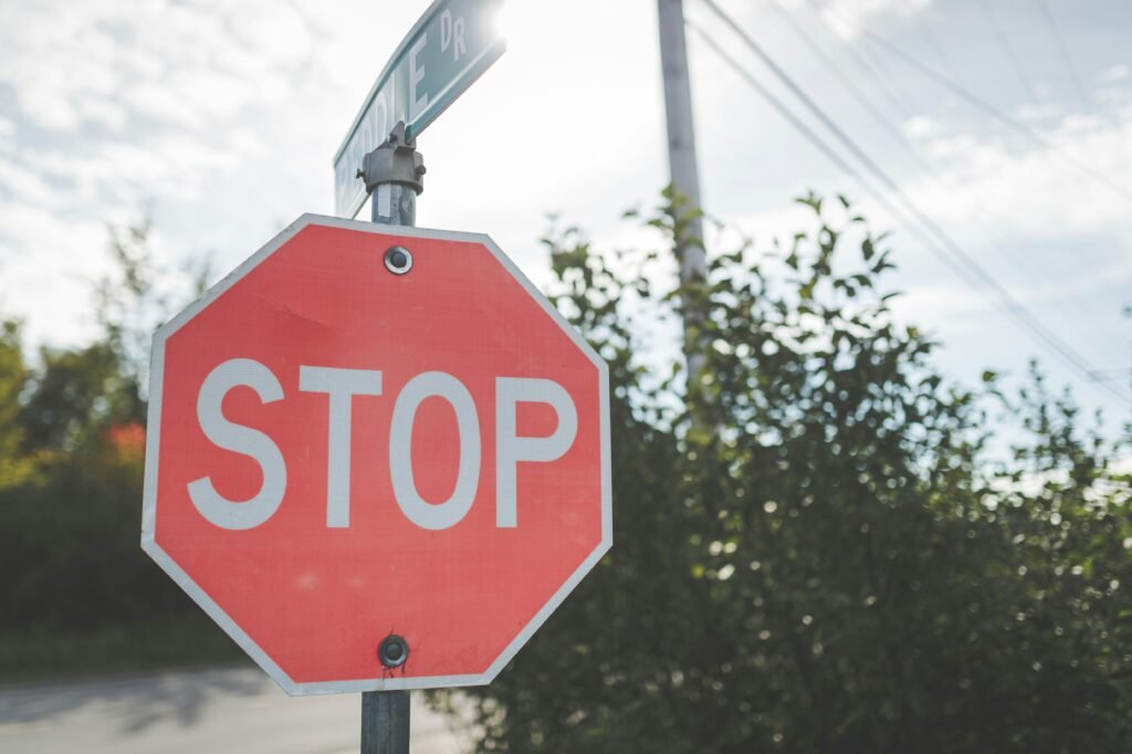 Eine Kreuzung mit einem Stopp-Schild und einem Auto, das vollständig anhält.