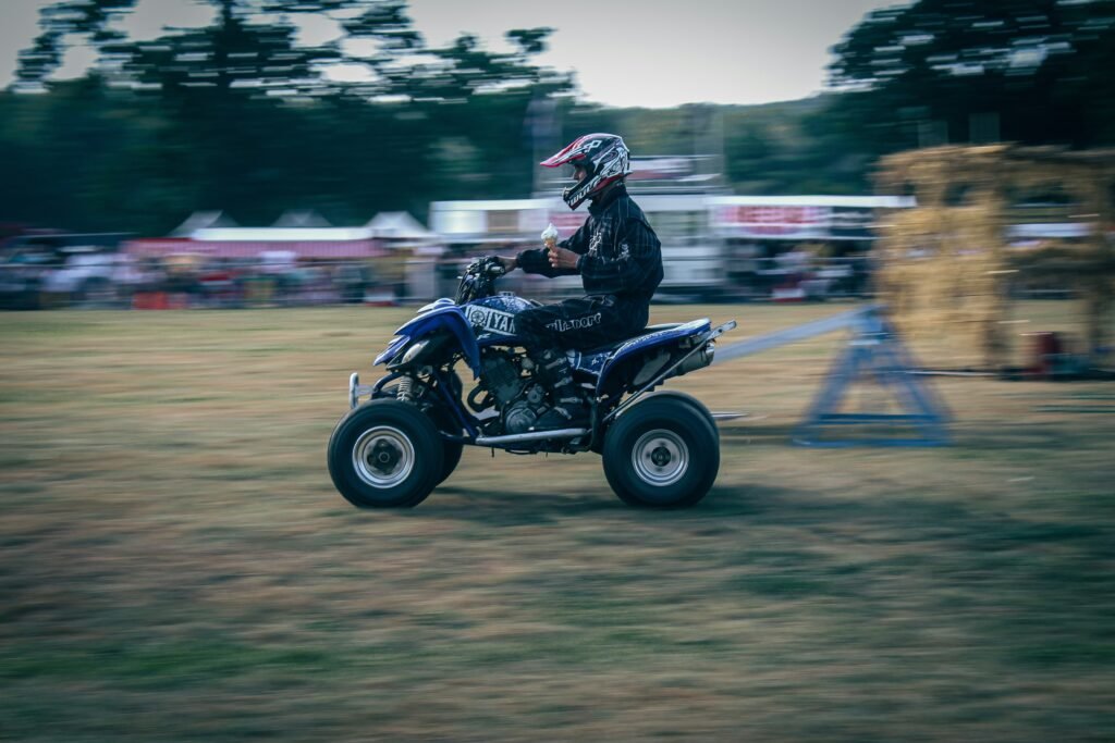 Person mit Helm fährt Quad im Gelände